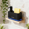 A black soap pump dispenser with a yellow sponge holder sits on a wooden shelf against a white tiled wall.