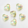 A collection of twenty clear, iridescent acrylic heart-shaped beads for jewelry making.