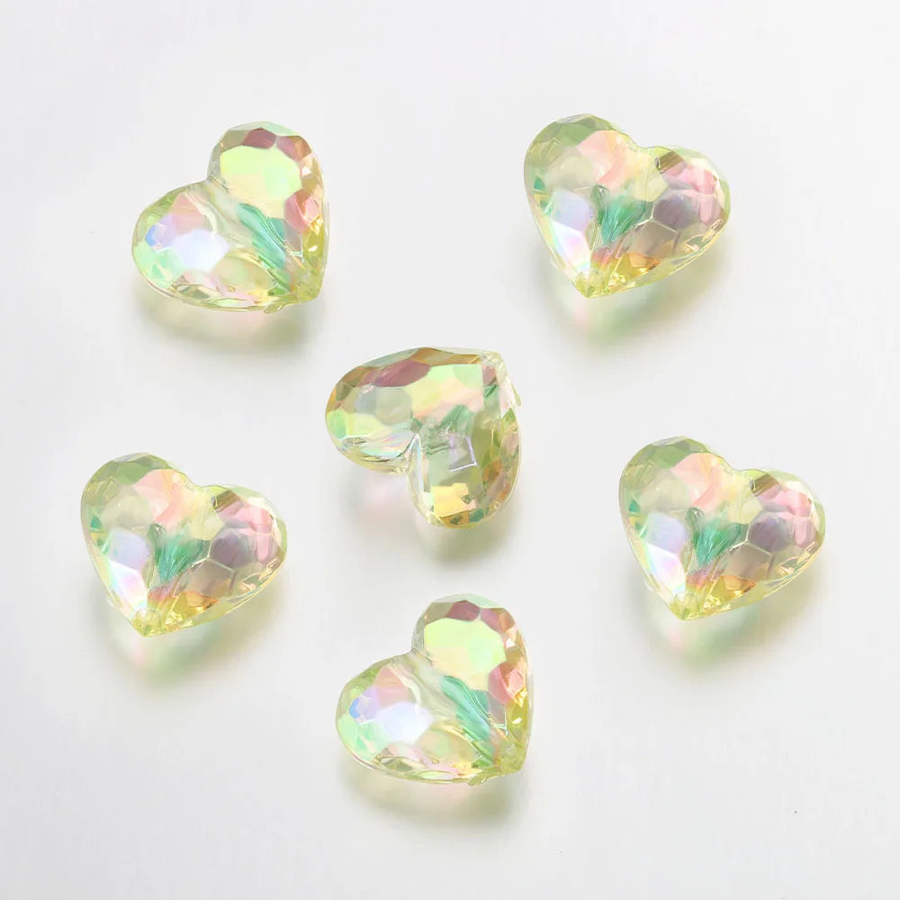 A collection of twenty clear, iridescent acrylic heart-shaped beads for jewelry making.