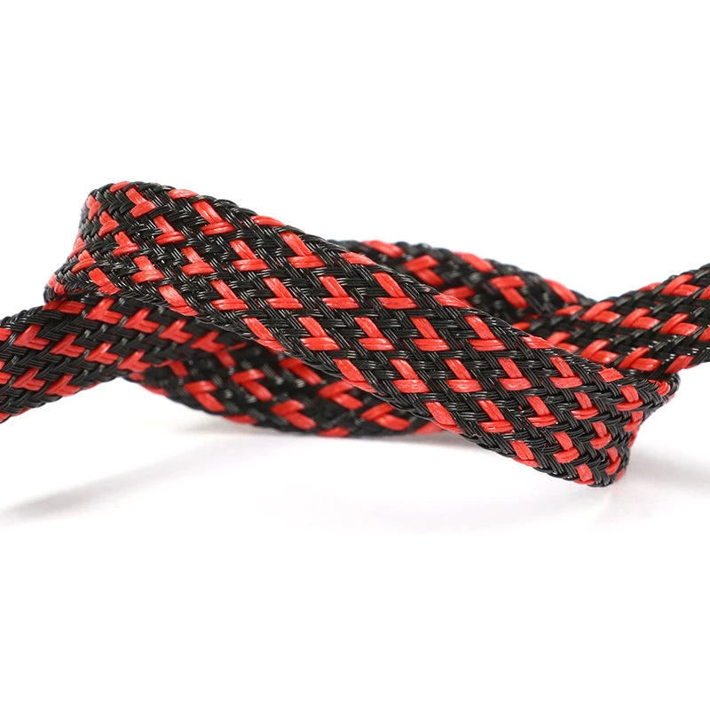 A close-up of a black and orange braided cable sleeve used for flexible wire protection.