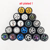 A collection of eleven plated 1:64 scale alloy car wheels and tires displayed in a pyramid formation.