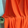 Orange stretch jersey fabric draped elegantly for backdrops and decor