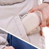 A hand opens a weekly pill organizer with eight compartments inside a light beige jacket pocket.