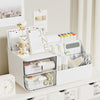 A white desk organizer with transparent drawers holds various stationery and office supplies.