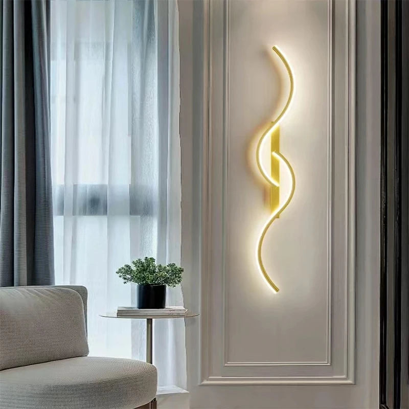 A modern minimalist LED wall lamp with a curved, glowing yellow light fixture mounted on a white wall.
