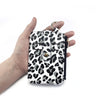 A hand holds a leopard print PU leather card holder with a coin pocket and keychain.