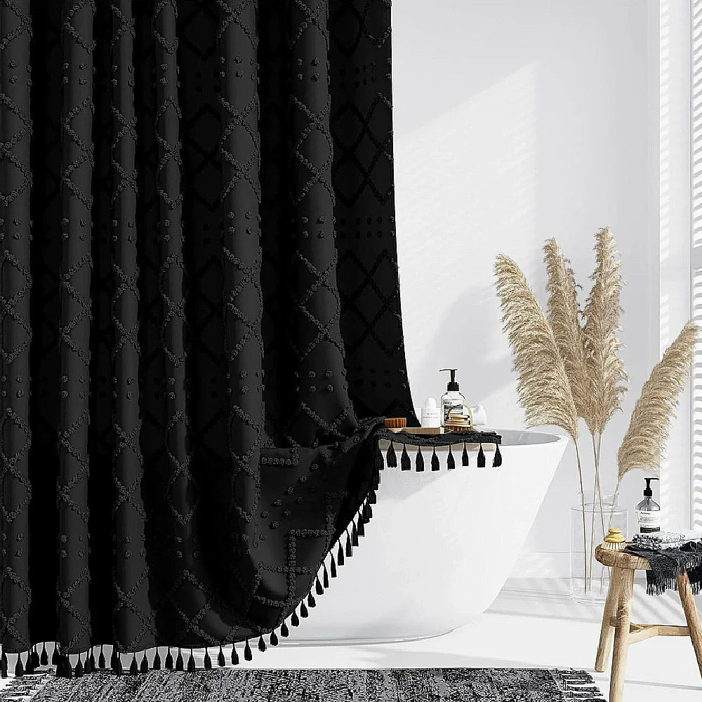 Black boho waterproof shower curtain with tassels and hooks displayed in a bright bathroom setting.