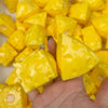 A hand holds bright yellow, cube-shaped fidget toys for stress relief.