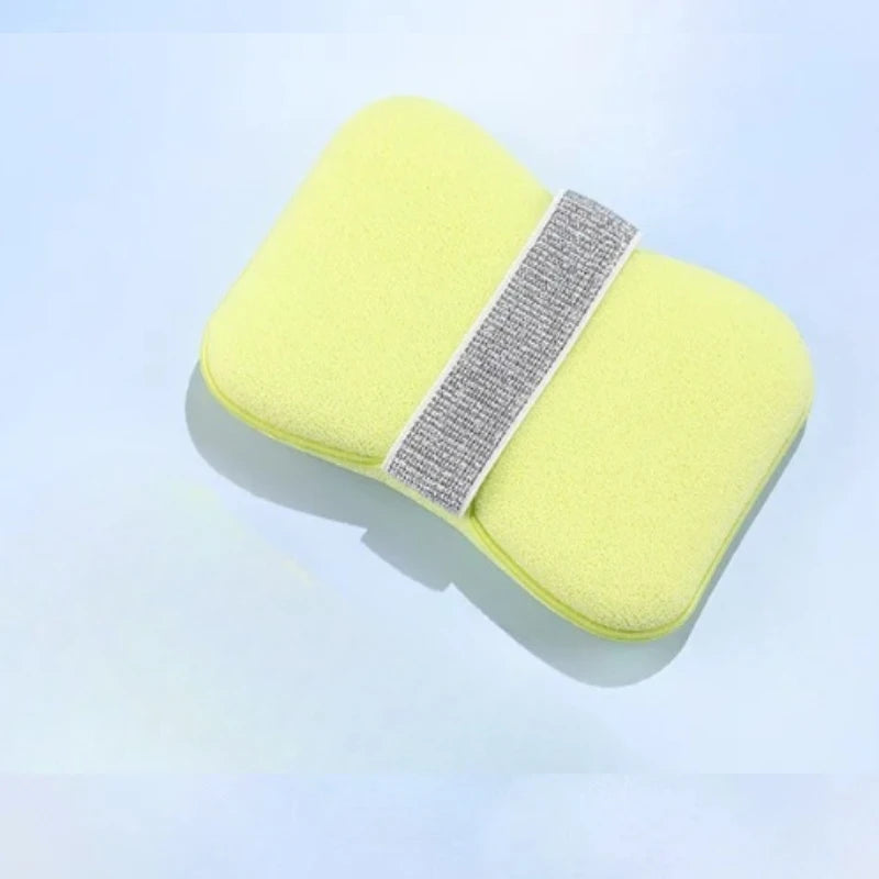 A bright yellow foaming soap saver bag with a gray exfoliating mesh strip is shown against a light blue background.