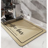 A black coffee grinder and water filter are placed on a yellow and black coffee bar mat on a marble countertop.