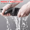 Hands are washing a black, highly absorbent microfiber cleaning cloth under running water.