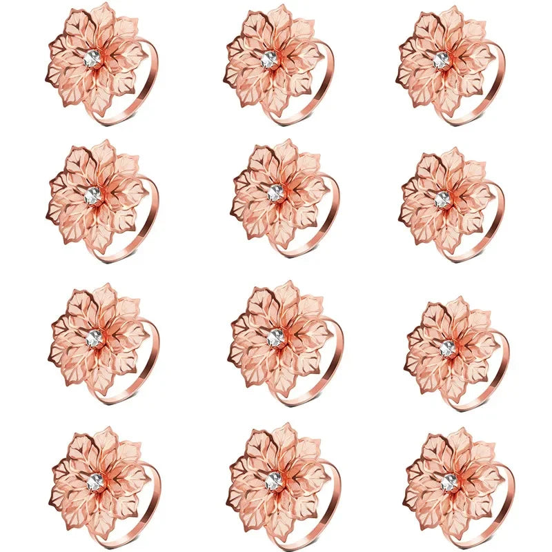 A set of twelve decorative metal napkin rings featuring a hollow-out floral pattern in a rose gold color.