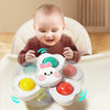 A baby is interacting with a set of spinning bath toys, including water wheels and a floating sphere.