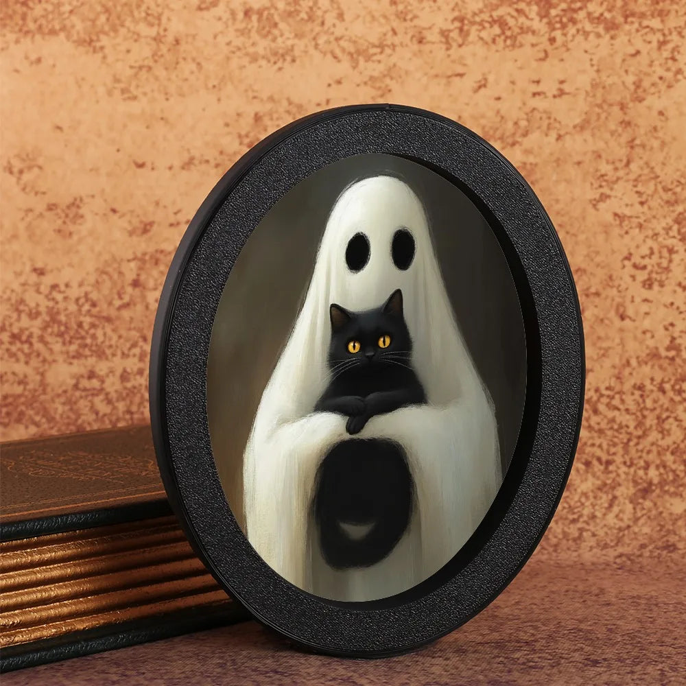 An oval decorative ornament featuring a ghost figure with white drapery and a black cat looking out.