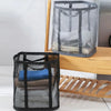 A black mesh laundry basket with a handle is shown on a wooden shelf, containing folded white and blue towels.