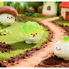 Hand-painted resin vegetable figurines, including mushrooms, peas, and pumpkins, displayed in a garden setting.