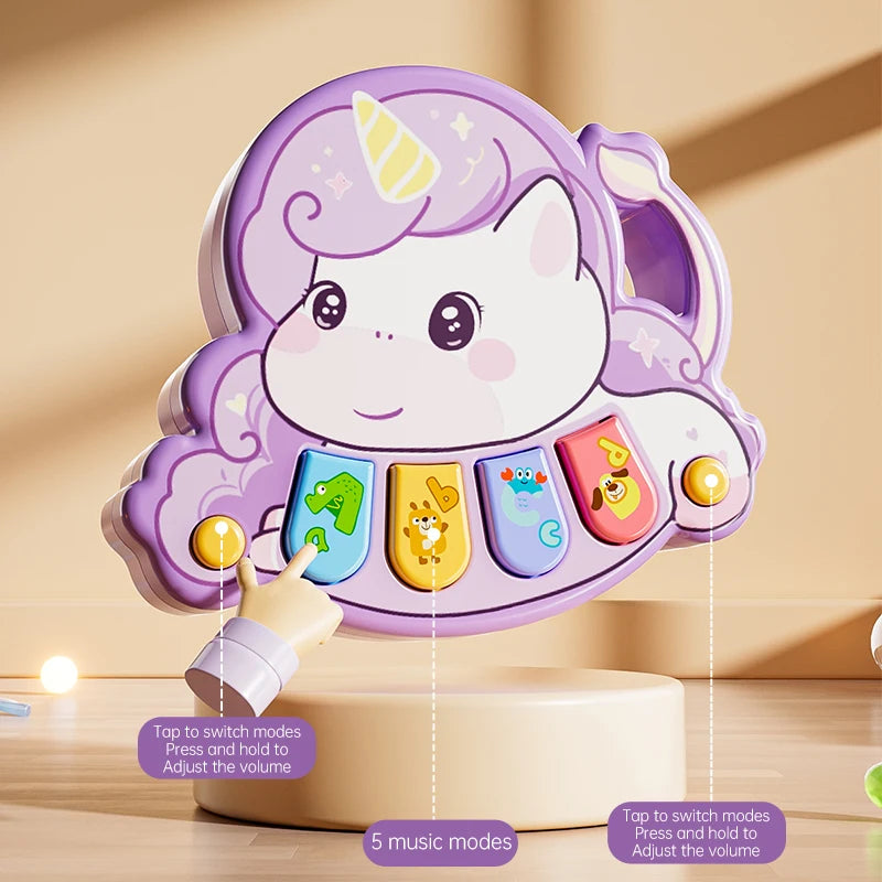 A purple unicorn-themed interactive piano toy with five colored keys and a light purple mane, shown on a wooden surface.