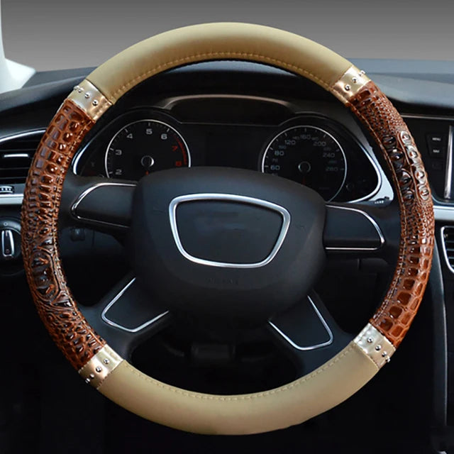 A close-up view of a brown crocodile grain leather car steering wheel cover on a black steering wheel.