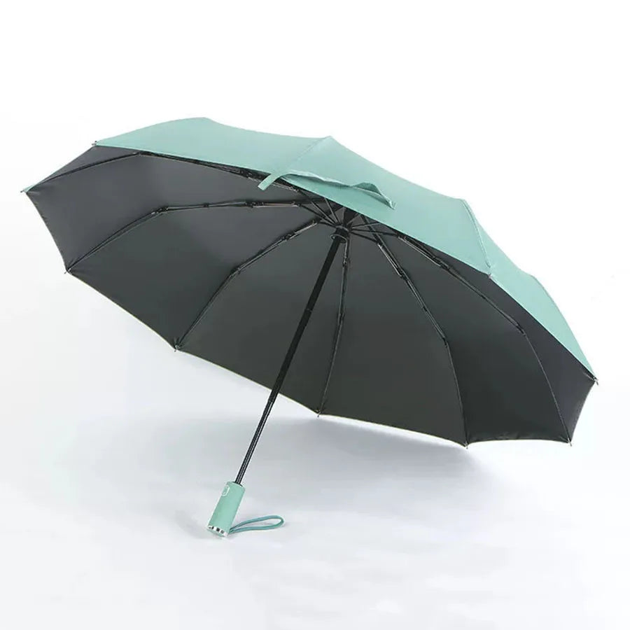 A black and mint green automatic foldable umbrella open and angled against a white background.