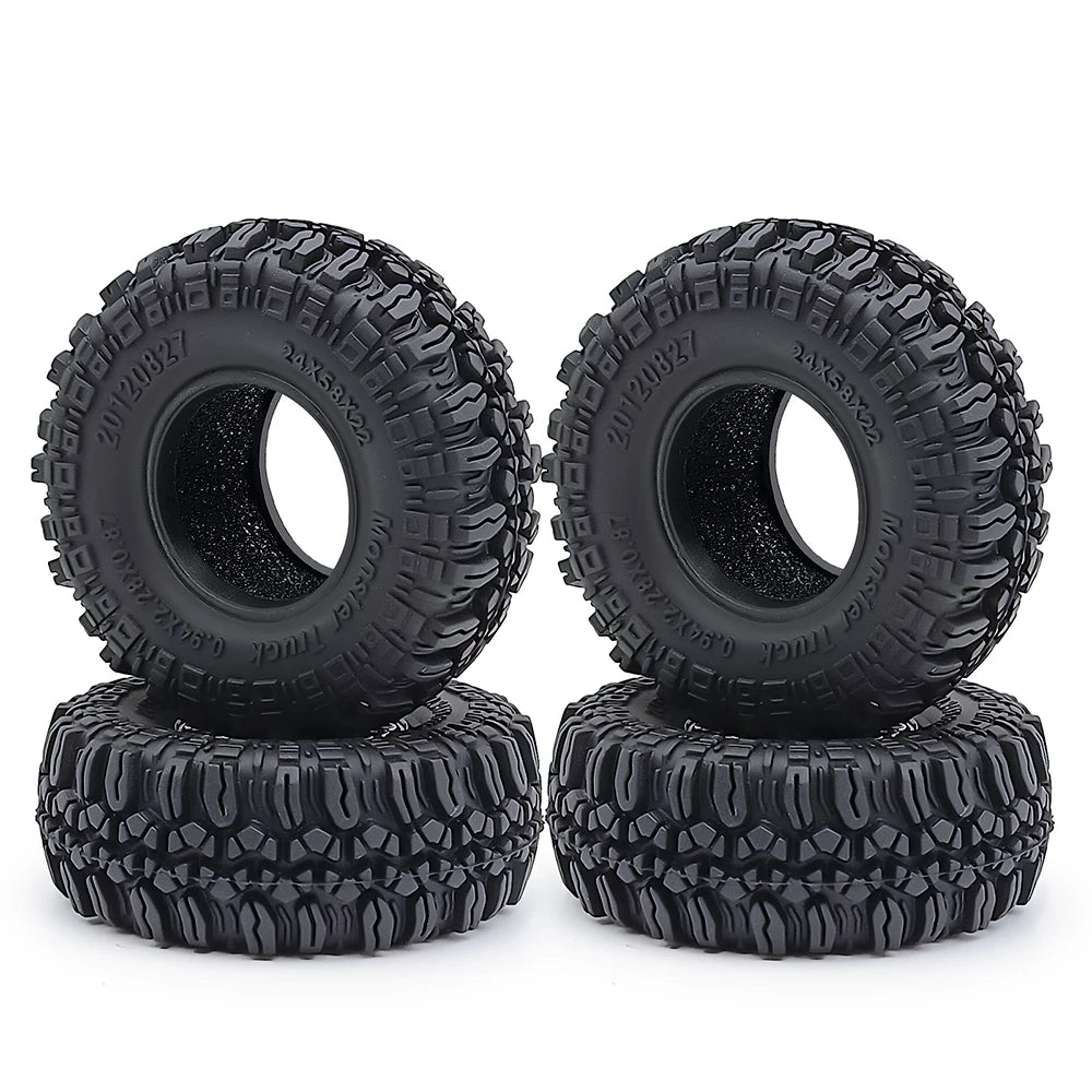 A pair of black rubber mud terrain tires with knobby treads mounted on black rims.