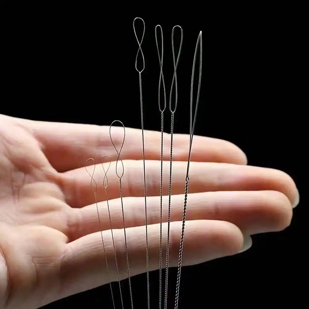 A hand holds a set of seven ultra-fine beading needles for jewelry making