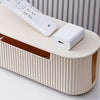 A beige cable management box with a lid and power strip organizer is shown on a white surface.