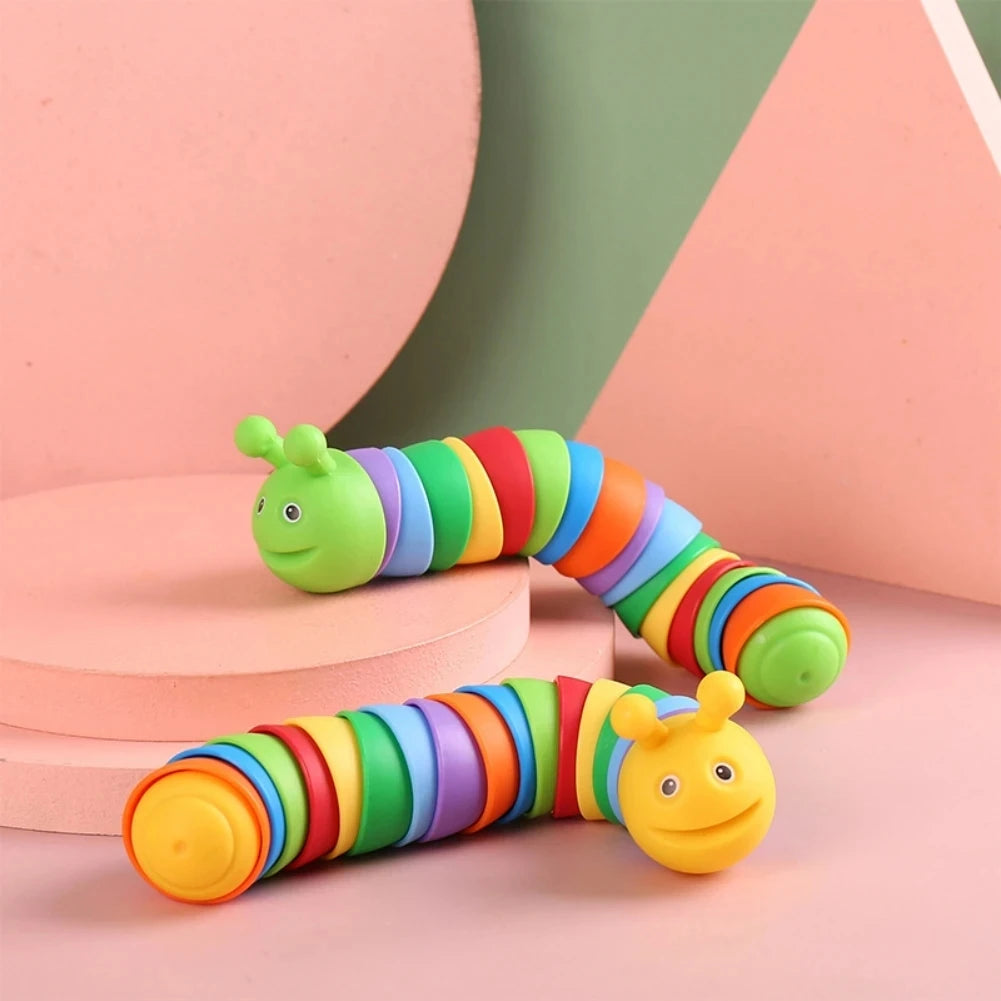 A colorful, articulated fidget slug toy with bright stripes is shown against a pink and green background.