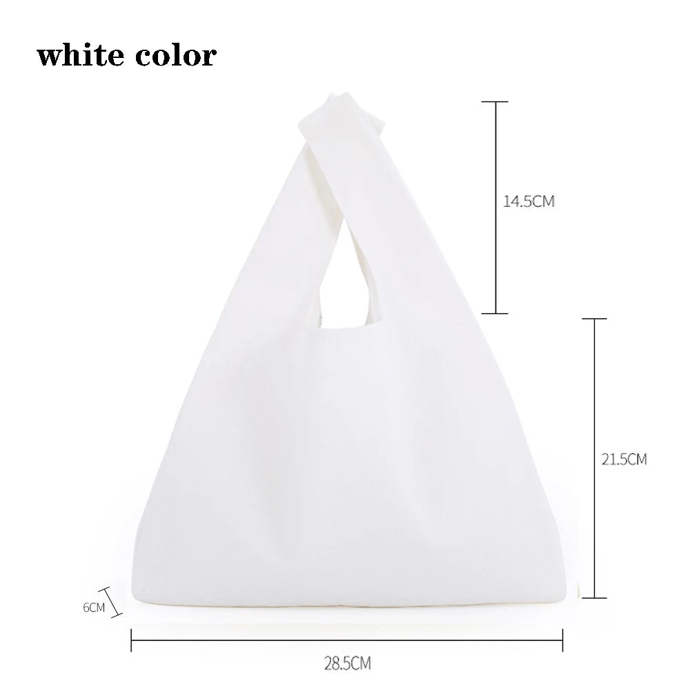 A white foldable canvas tote bag shown from the front, displaying its size and shape.