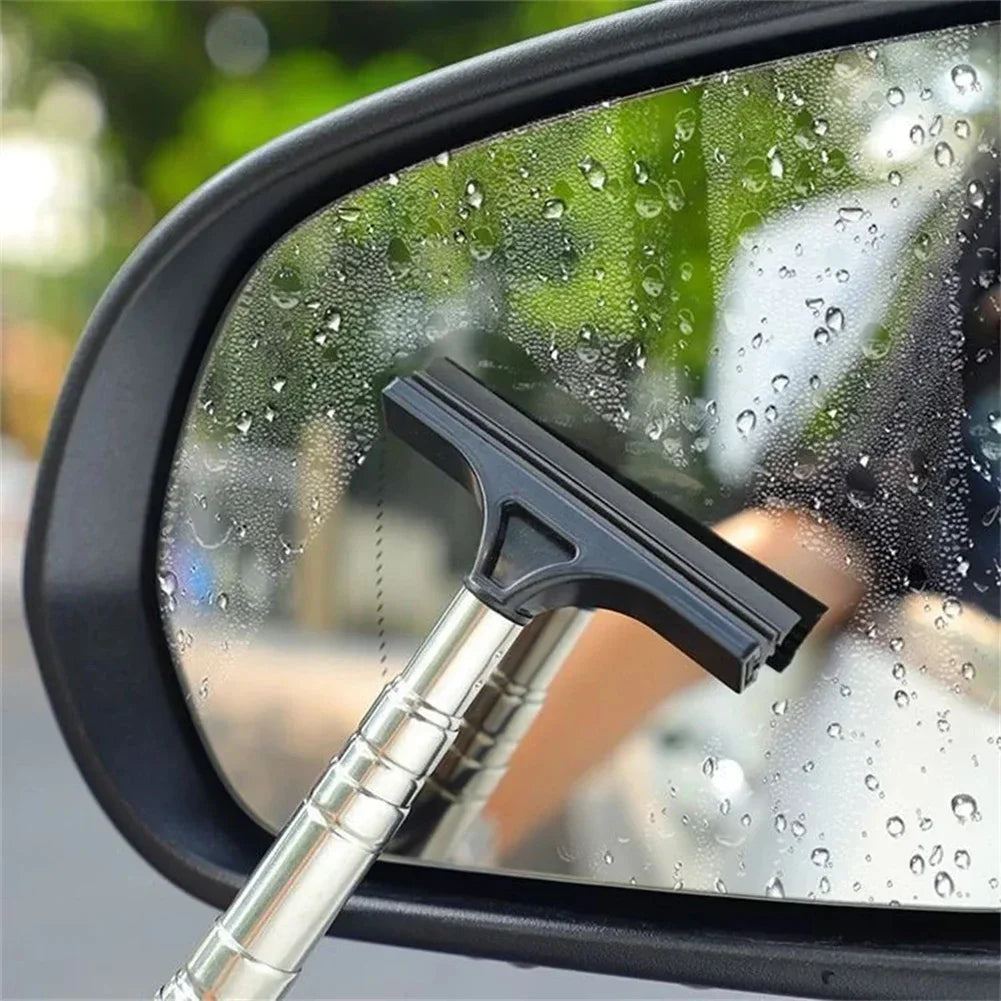 A black telescopic window cleaning squeegee with an adjustable silver handle is visible on a wet car window.