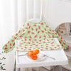 A green long-sleeve waterproof baby bib with a cute animal pattern displayed on a white table.