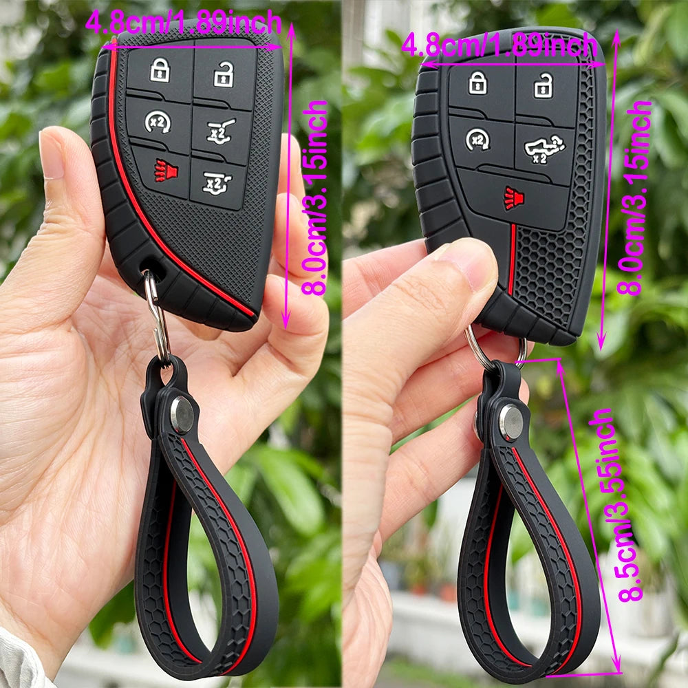 A black silicone key fob cover with a keyring attached, shown being held by a hand.
