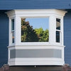 A white window with a decorative trim and a gray privacy film applied to the lower pane.