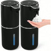 A black touchless automatic soap dispenser with a white pump head and blue indicator light is held by a hand.