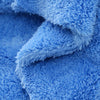 A close-up of a bright blue, fluffy microfiber cleaning cloth being folded or draped.