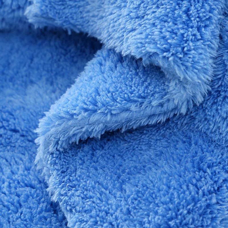 A close-up of a bright blue, fluffy microfiber cleaning cloth being folded or draped.