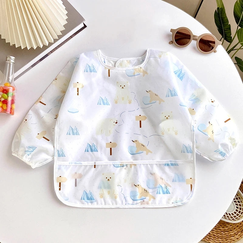 A white waterproof long-sleeve baby feeding smock featuring cute bear and deer patterns on a white background.