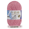 A ball of pink milk cotton blend yarn with a label in Chinese and English.