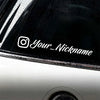 A close-up of a black motorcycle helmet featuring a white Instagram logo and the text Your_Nickname decal.