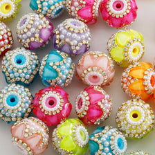 A collection of colorful rhinestone round beads in various shades including pink, purple, yellow, and blue.