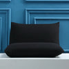 A black soft brushed microfiber pillow is displayed against a blue paneled wall.
