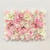 A dense wall panel of pink and white silk rose flowers for weddings and events.