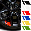 A close-up view of a black car wheel hub with various reflective stickers in red, blue, yellow, and green.