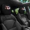 Two black car headrest covers with visible eye prints are shown inside a vehicle cabin.