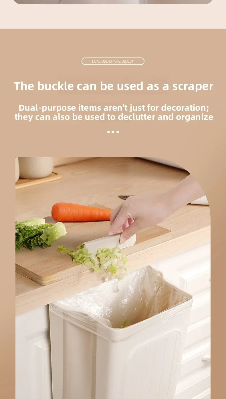 A hand is using a buckle to scrape food scraps into a foldable hanging trash bin in a kitchen setting.