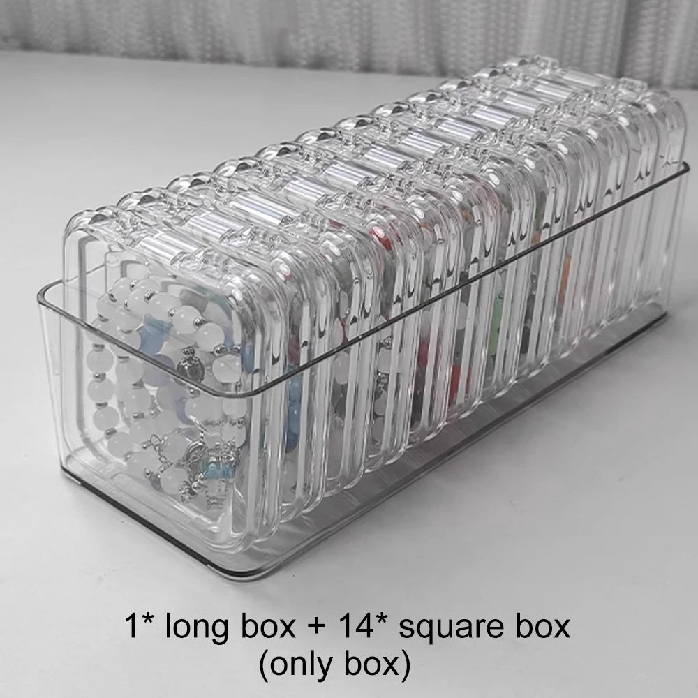 A clear long box containing fourteen square compartments for jewelry organization.