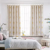 Light beige embroidered curtains with lace trim framing a window in a bright room.