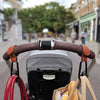 A close-up of a brown leather strap and hooks attached to a stroller bag organizer.