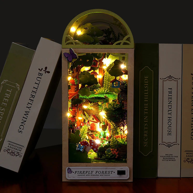 A DIY book nook kit featuring a miniature forest scene with glowing lights and foliage.