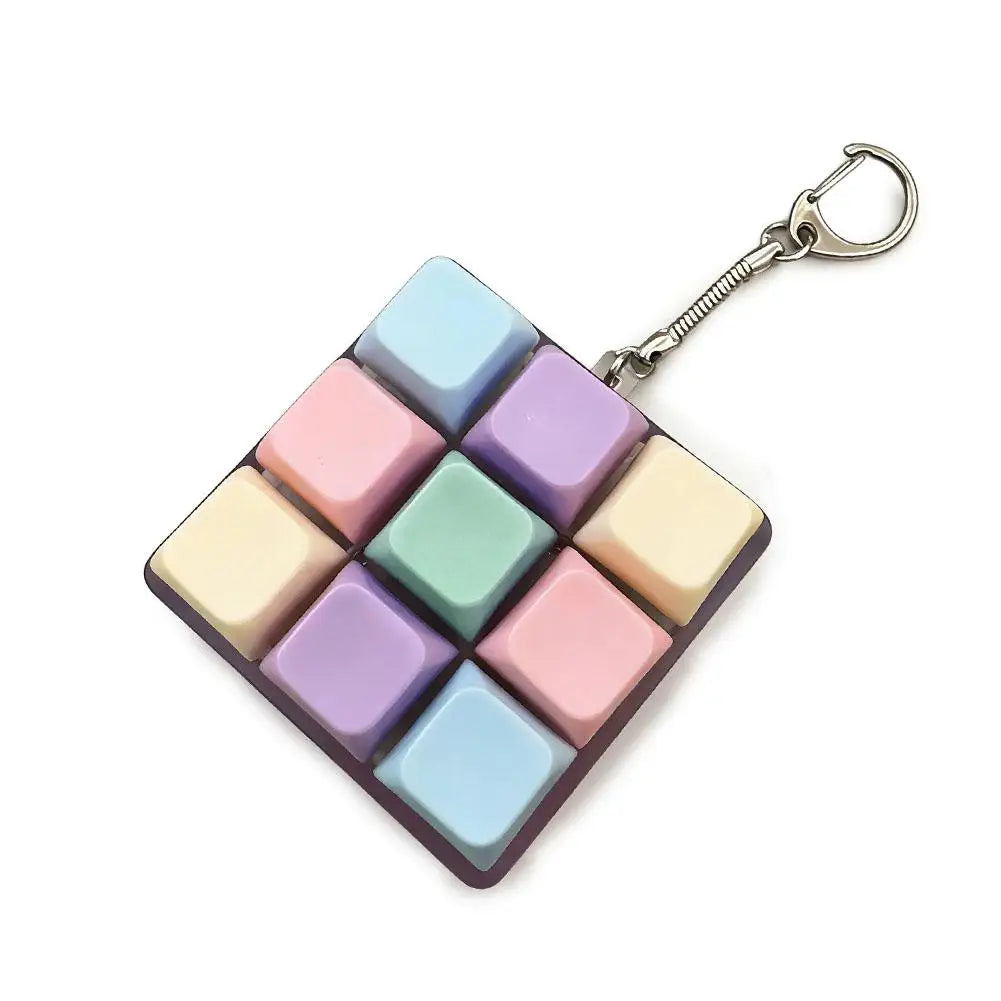 A square fidget keychain featuring multiple pastel colored mechanical keyboard switches attached to a silver keyring.