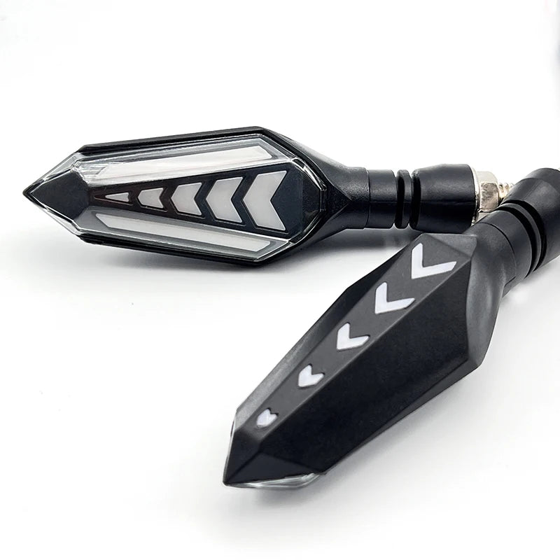 A black motorcycle turn signal indicator with a clear lens and chevron pattern.